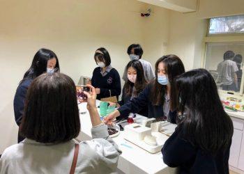 參訪同學對廚房輔具感到興趣，練習使用輔助湯匙夾取食物。