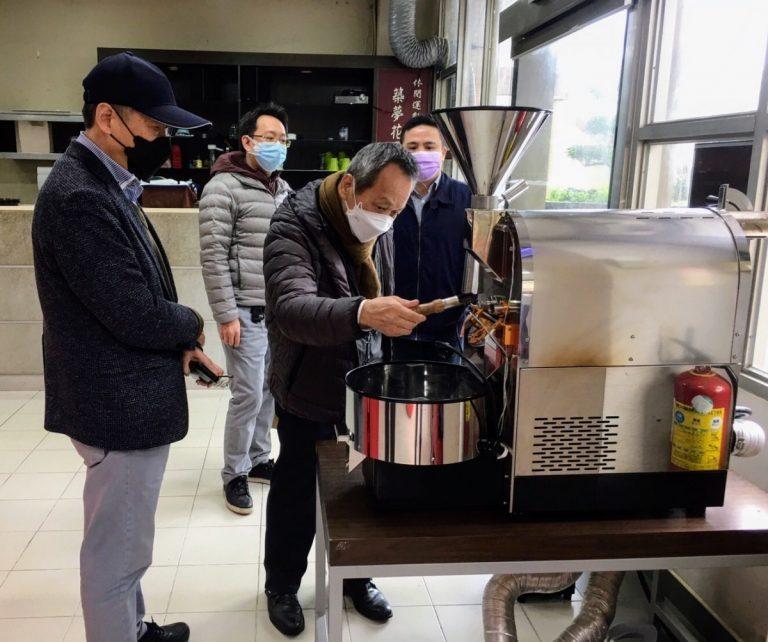 游啟明董事長（右二）仔細觀看築夢花園實習咖啡廳的咖啡烘焙機。