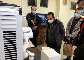 游啟明董事長（左二）參觀工業管理系的機器手臂咖啡機。