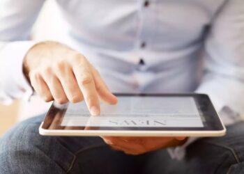 Man-holding-a-digital-tablet-and-reading-news
