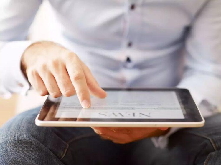 Man-holding-a-digital-tablet-and-reading-news