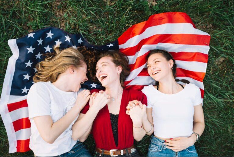 independence-day-concept-with-girls-lying-american-flag