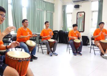 肯納青年開心的學習非洲鼓打擊樂器。圖片來源臺中肯納自閉症基金會提供