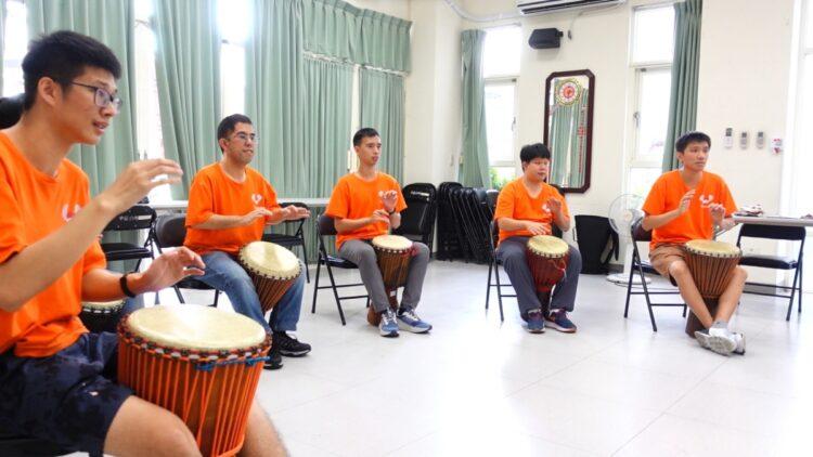 肯納青年開心的學習非洲鼓打擊樂器。圖片來源臺中肯納自閉症基金會提供