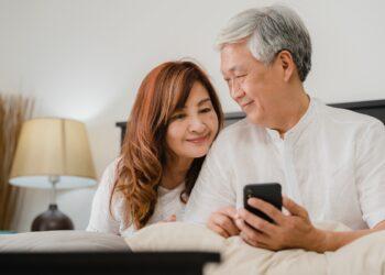 asian-senior-couple-using-mobile-phone-home-asian-senior-chinese-grandparents-husband-wife-happy-after-wake-up-watching-movie-lying-bed-bedroom-home-morning-concept