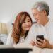 asian-senior-couple-using-mobile-phone-home-asian-senior-chinese-grandparents-husband-wife-happy-after-wake-up-watching-movie-lying-bed-bedroom-home-morning-concept